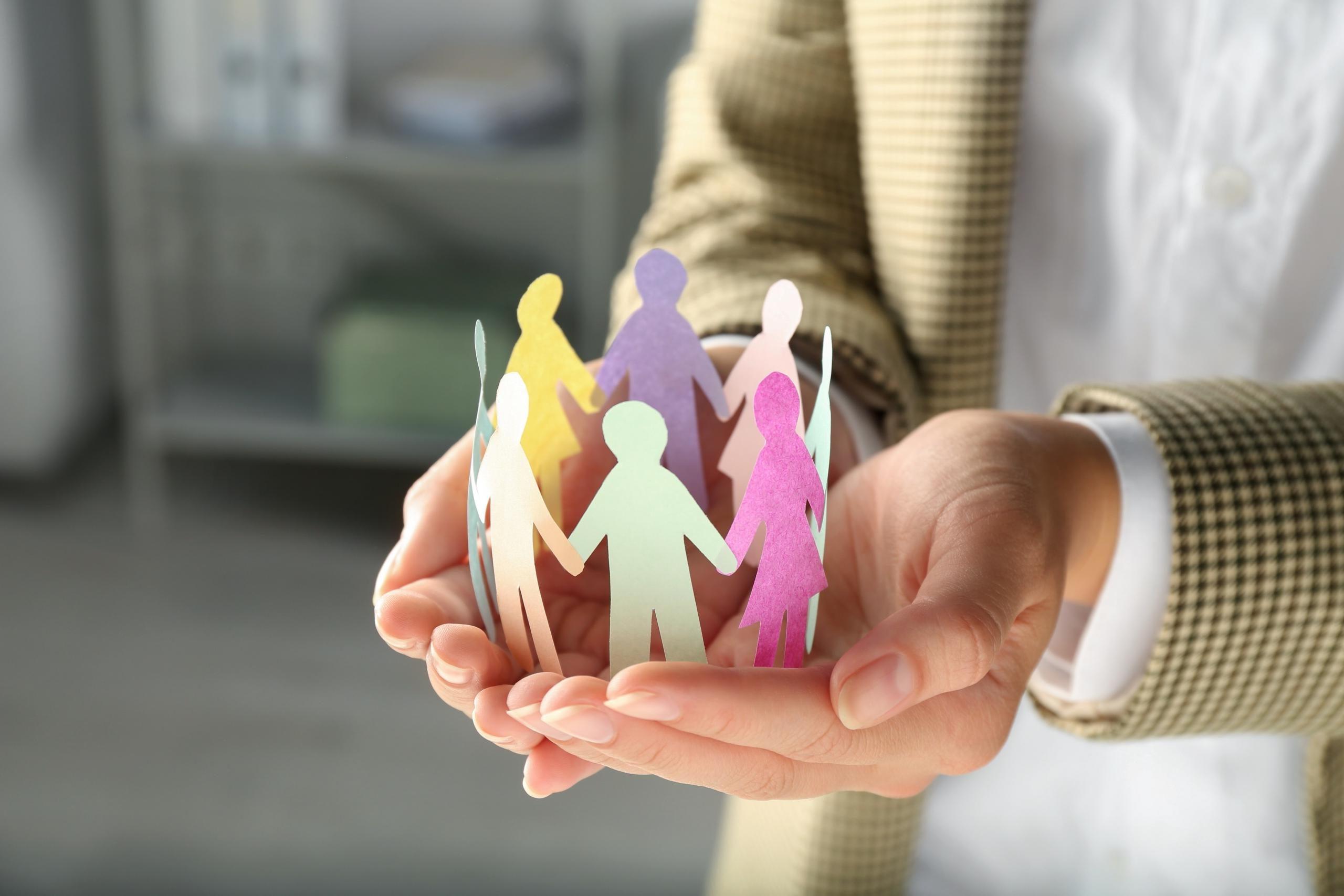 woman holding paper human figures on blurred backg 2026 02 02 03 16 30 utc